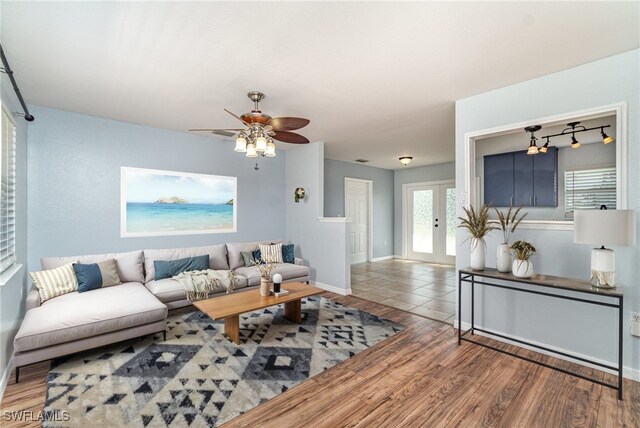 living room featuring a ceiling fan, wood finished floors, and baseboards