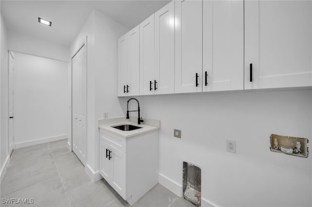 clothes washing area featuring cabinet space, washer hookup, baseboards, and electric dryer hookup