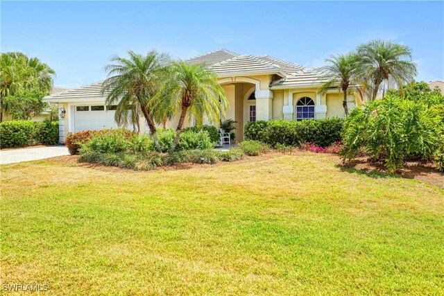 28839 Winthrop Cir, Bonita Springs, FL 34134 - view of front of home featuring an attached garage, stucco siding, a front yard, and a tile roof