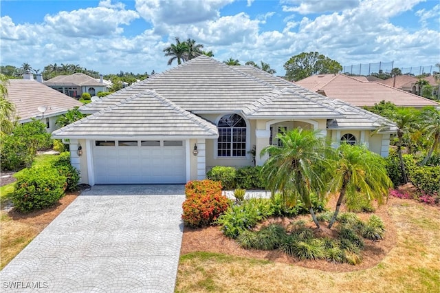 28839 Winthrop Cir, Bonita Springs, FL 34134 - view of front of property featuring a garage, driveway, a tiled roof, and stucco siding