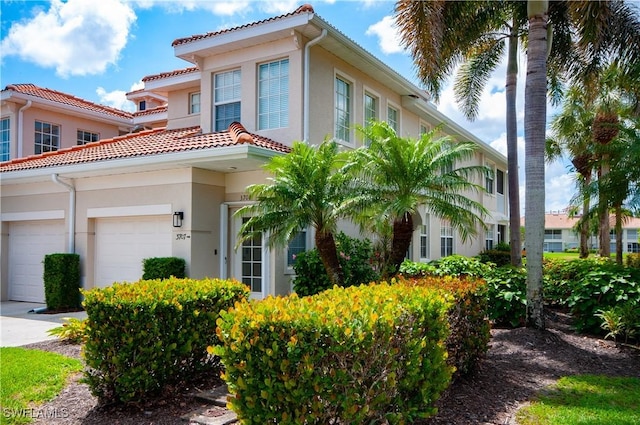 3045 Driftwood Way Unit 3707, Naples, FL 34109 - view of front facade with stucco siding, an attached garage, and a tile roof