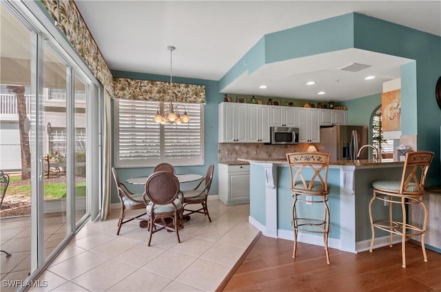 3045 Driftwood Way Unit 3707, Naples, FL 34109 - kitchen with appliances with stainless steel finishes, plenty of natural light, a chandelier, and a kitchen bar