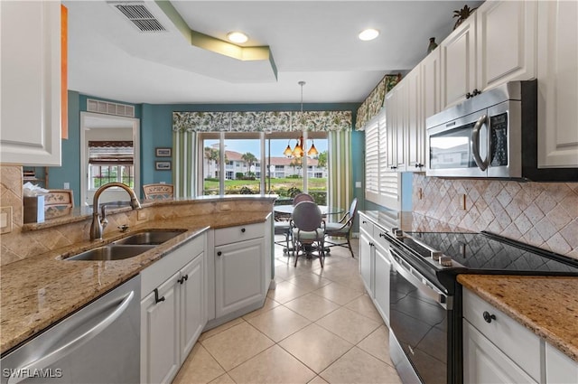 3045 Driftwood Way Unit 3707, Naples, FL 34109 - kitchen with stainless steel appliances, a sink, a chandelier, decorative backsplash, and white cabinetry