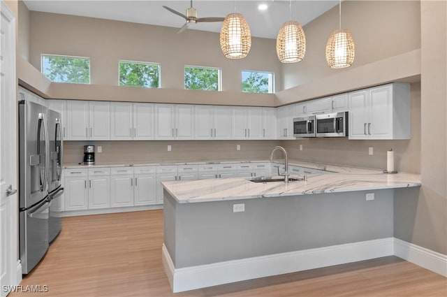 3045 Driftwood Way Unit 3707, Naples, FL 34109 - kitchen featuring a sink, a high ceiling, appliances with stainless steel finishes, a peninsula, and white cabinets
