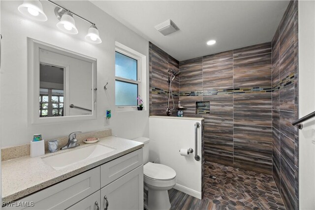 bathroom featuring walk in shower, healthy amount of natural light, toilet, vanity, and recessed lighting