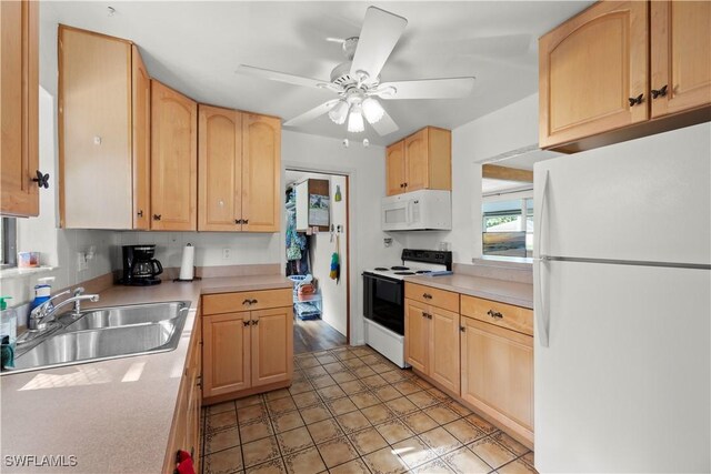 kitchen featuring white appliances, a sink, light brown cabinets, light countertops, and ceiling fan