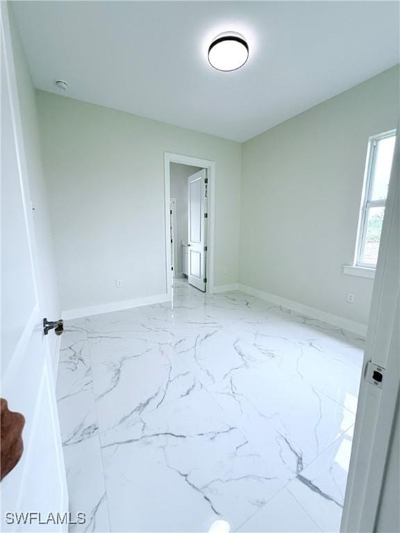 1312 Oak Ave, Lehigh Acres, FL 33972 - empty room featuring marble look tiles and baseboards