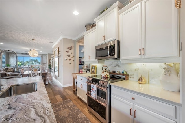 28268 Seasons Tide Ave, Bonita Springs, FL 34135 - kitchen featuring stainless steel appliances, wood finished floors, white cabinetry, tasteful backsplash, and open floor plan