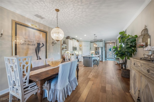 28268 Seasons Tide Ave, Bonita Springs, FL 34135 - dining area featuring a chandelier, hardwood / wood-style floors, crown molding, and recessed lighting