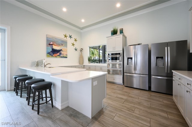 28268 Seasons Tide Ave, Bonita Springs, FL 34135 - kitchen with stainless steel appliances, a warming drawer, a breakfast bar area, light wood finished floors, and light countertops
