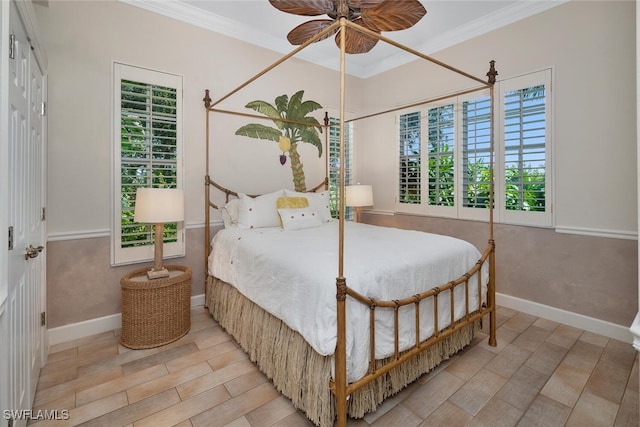 bedroom featuring ornamental molding, baseboards, wood finished floors, and a ceiling fan