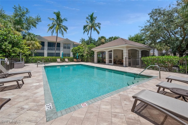 community pool with fence and a patio