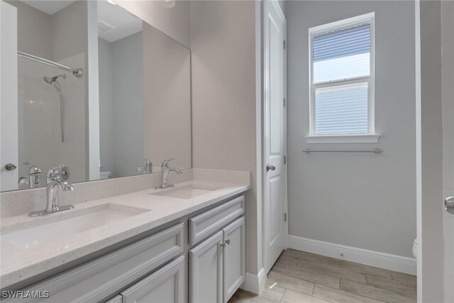 3307 Pilot Cir, Naples, FL 34120 - full bath featuring baseboards, double vanity, toilet, a shower, and wood finished floors