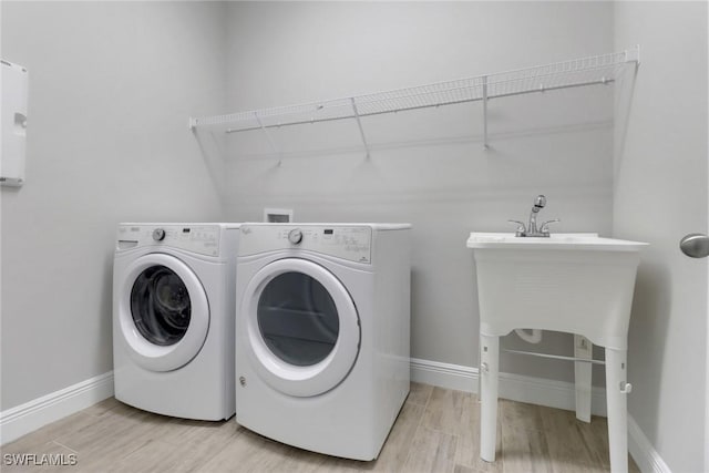 3307 Pilot Cir, Naples, FL 34120 - clothes washing area featuring light wood finished floors, washer and dryer, and baseboards