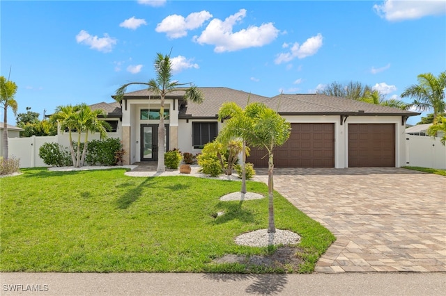 view of front of home featuring decorative driveway, an attached garage, stucco siding, and a gate