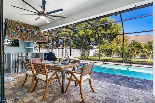 view of patio with a ceiling fan, glass enclosure, and outdoor dining area