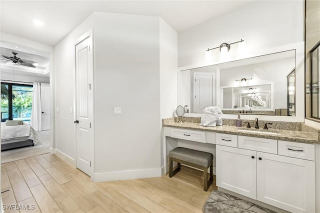 ensuite bathroom with wood finished floors, baseboards, ceiling fan, vanity, and recessed lighting