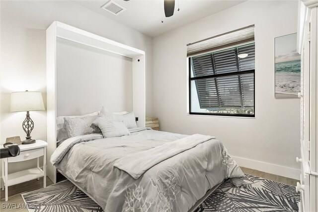 bedroom with wood finished floors, baseboards, and ceiling fan