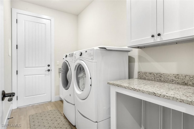 laundry area featuring independent washer and dryer, cabinet space, and light wood-type flooring