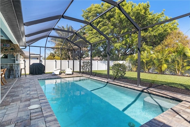 view of swimming pool with a patio area and a lanai