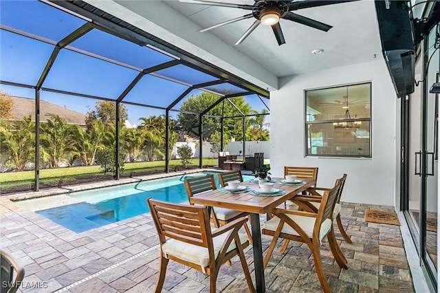view of pool featuring a patio area, a ceiling fan, outdoor dining area, and glass enclosure