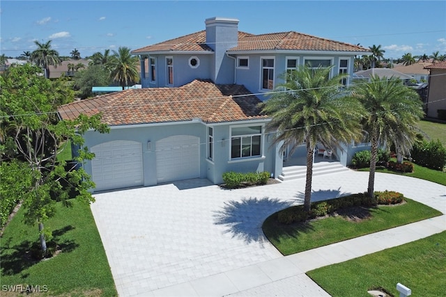 1070 Dana Ct, Marco Island, FL 34145 - mediterranean / spanish home with a garage, decorative driveway, a tiled roof, stucco siding, and a front yard