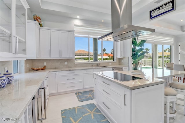 1070 Dana Ct, Marco Island, FL 34145 - kitchen with island range hood, black electric stovetop, a sink, decorative backsplash, and a kitchen bar