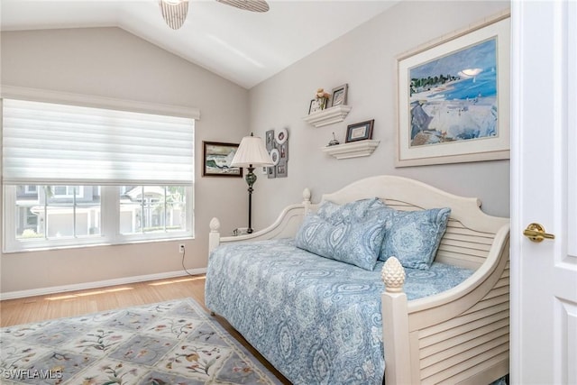 bedroom with wood finished floors, vaulted ceiling, baseboards, and a ceiling fan