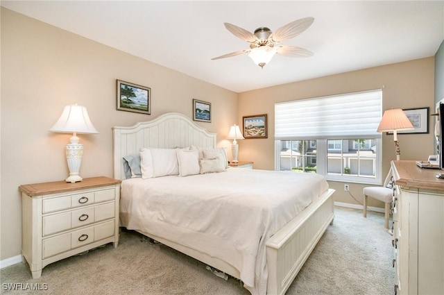 bedroom with light colored carpet, baseboards, and ceiling fan