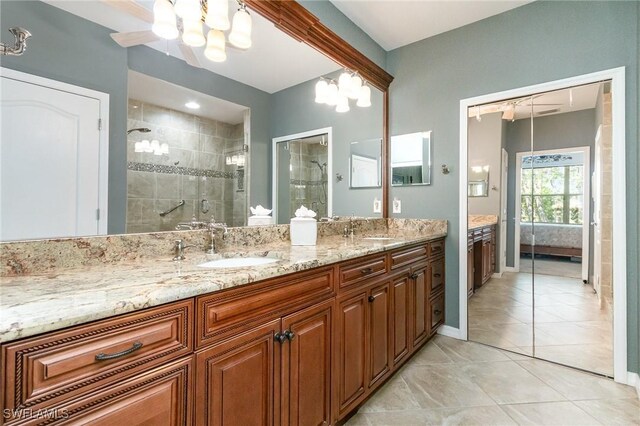 full bathroom with a shower stall, double vanity, ensuite bathroom, a chandelier, and baseboards