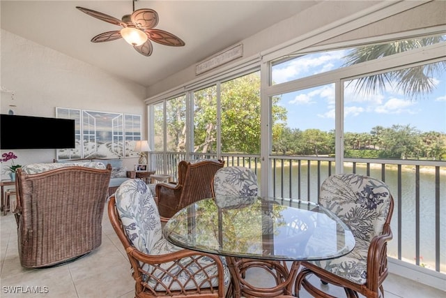 sunroom with outdoor dining space, vaulted ceiling, ceiling fan, and a water view