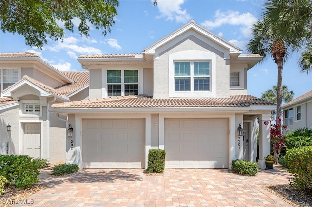 view of front of property with stucco siding, decorative driveway, and a tile roof
