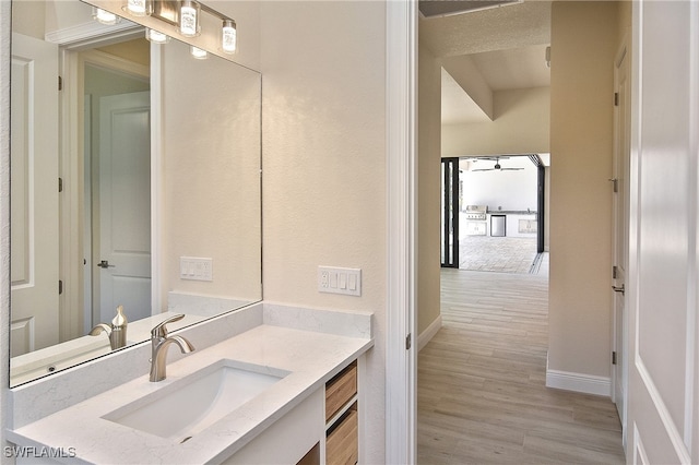 bathroom featuring wood finished floors, vanity, and baseboards