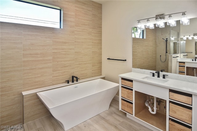 full bath with a walk in shower, a freestanding bath, and vanity