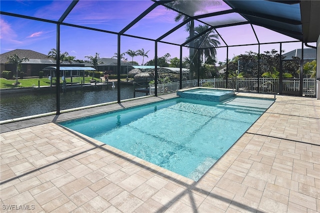 view of swimming pool featuring a patio area, a pool with connected hot tub, and a lanai