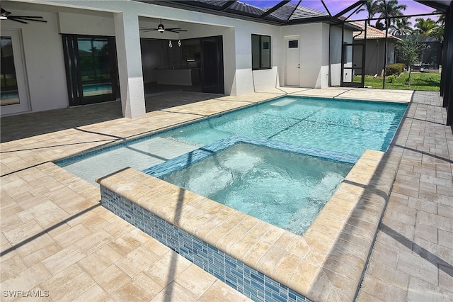 view of swimming pool with ceiling fan, a patio area, and a pool with connected hot tub