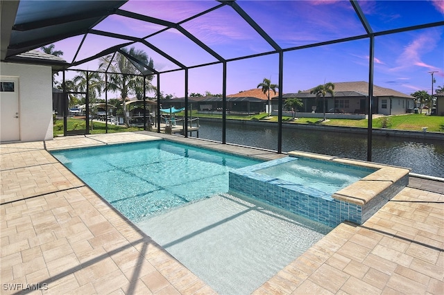 pool at dusk featuring a patio, a water view, a lanai, and a pool with connected hot tub