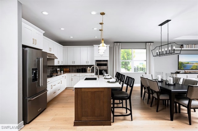 9102 Wisteria Way, Naples, FL 34114 - kitchen with stainless steel appliances, a sink, white cabinets, light wood-style flooring, and recessed lighting