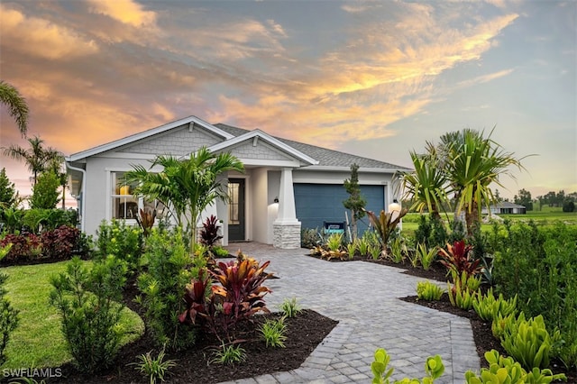 9102 Wisteria Way, Naples, FL 34114 - view of front of home featuring a garage, decorative driveway, and stucco siding