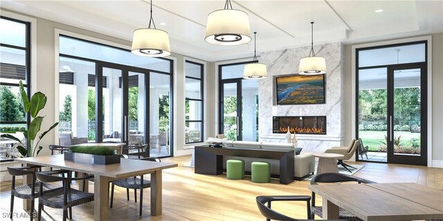 9102 Wisteria Way, Naples, FL 34114 - dining space featuring a high end fireplace, light wood-type flooring, and a tray ceiling