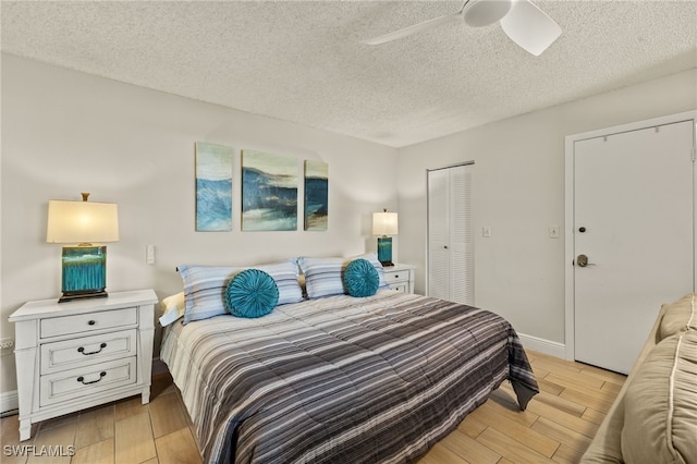 5900 Bonita Beach Rd # 1405, Bonita Springs, FL 34134 - bedroom with light wood finished floors, a textured ceiling, baseboards, a ceiling fan, and a closet