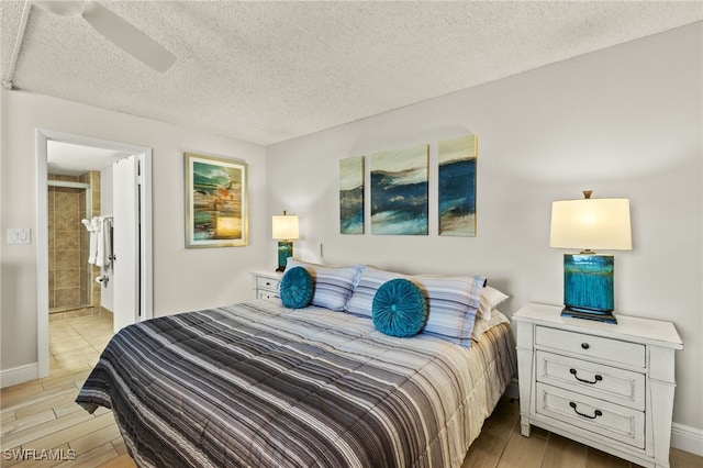 5900 Bonita Beach Rd # 1405, Bonita Springs, FL 34134 - bedroom featuring light wood-type flooring, a textured ceiling, ensuite bathroom, baseboards, and a ceiling fan
