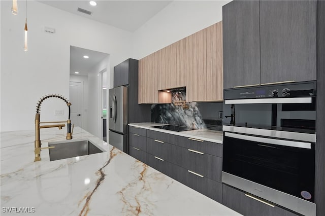 103 Chiquita Blvd N, Cape Coral, FL 33993 - kitchen with black appliances, a sink, modern cabinets, light stone countertops, and hanging light fixtures
