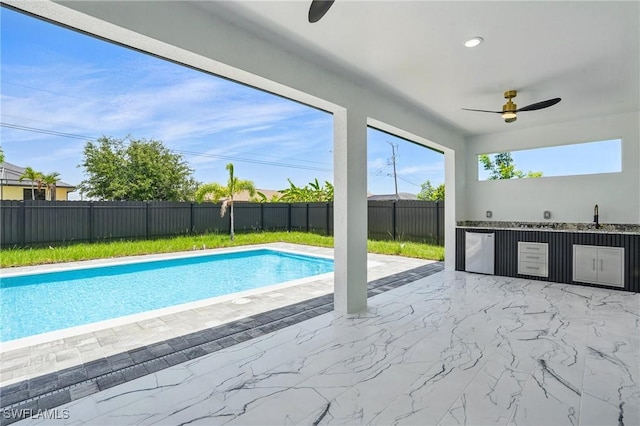 103 Chiquita Blvd N, Cape Coral, FL 33993 - view of pool featuring ceiling fan, exterior kitchen, a fenced backyard, a patio, and a sink