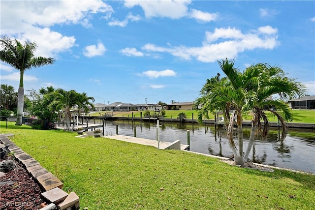 dock area with a water view, a lawn, and a residential view