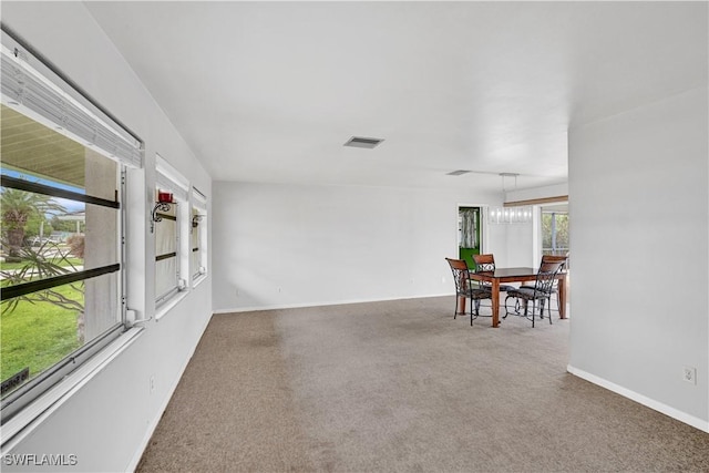 carpeted dining room with baseboards