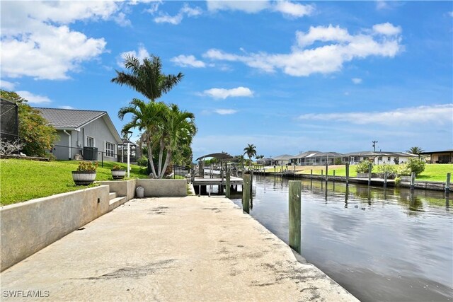 dock area with a residential view, a water view, and a yard