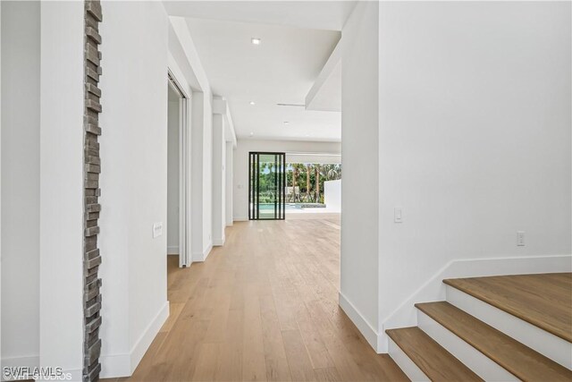 hallway with light wood-style floors and baseboards