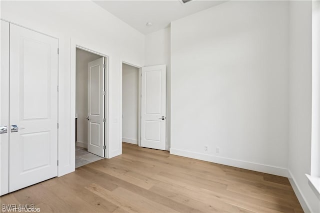 unfurnished bedroom featuring light wood-type flooring and baseboards