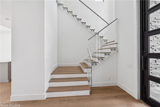 stairway featuring baseboards and wood finished floors